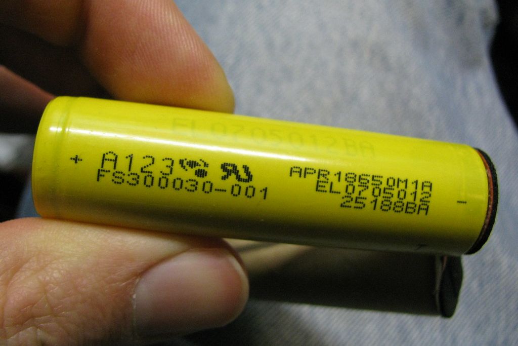A cylindrical lithium-ion cell held between two fingers