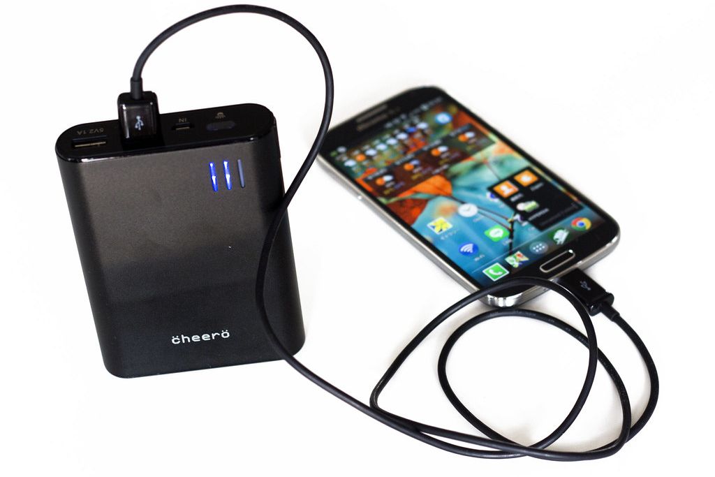 A portable power bank connected to a smartphone