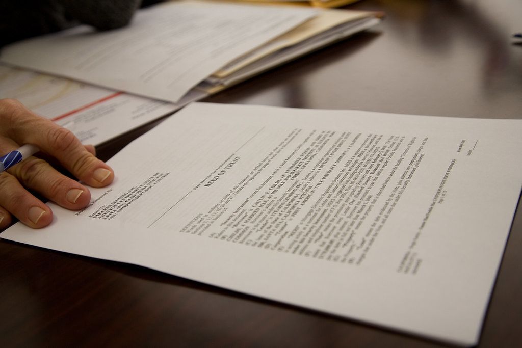 Printed paperwork on a desk with a pen